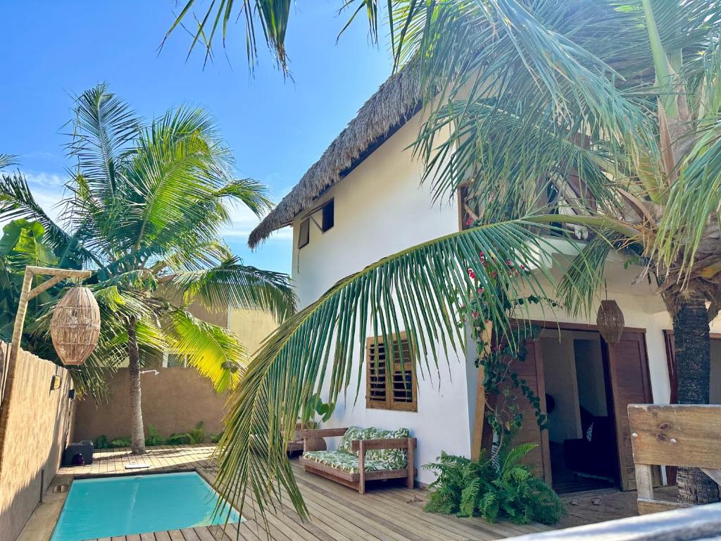 une villa avec une piscine et des palmiers dans l'établissement Kanaloa Village 02, à Icaraí