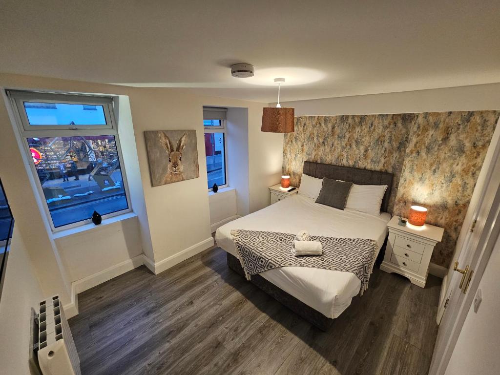 1 dormitorio con 1 cama y 2 ventanas en Tribeca Stay, en Galway