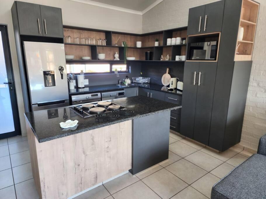 a kitchen with black cabinets and a stove top oven at Home@Micasa Unit 95 in Potchefstroom
