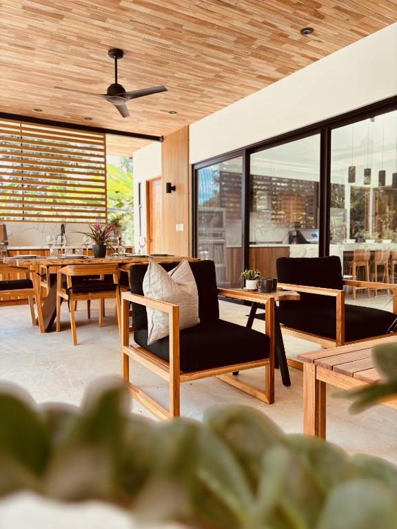- un salon avec des tables, des chaises et des fenêtres dans l'établissement Casa Emateena, à Uvita