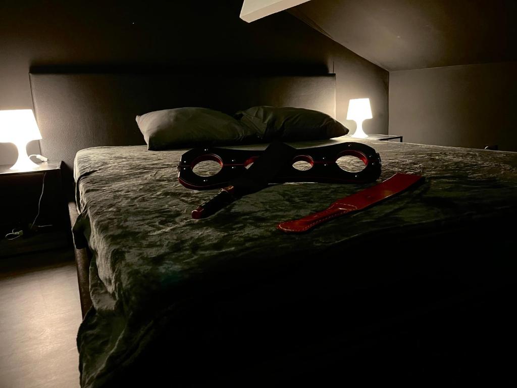 a bed with a pair of goggles on top of it at Amour d&#39;une Nuit, LoveRoom in Sarcelles
