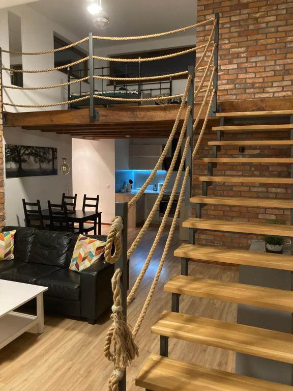a spiral staircase in a living room with a couch at A4 Luxury Apartment in Wrocław