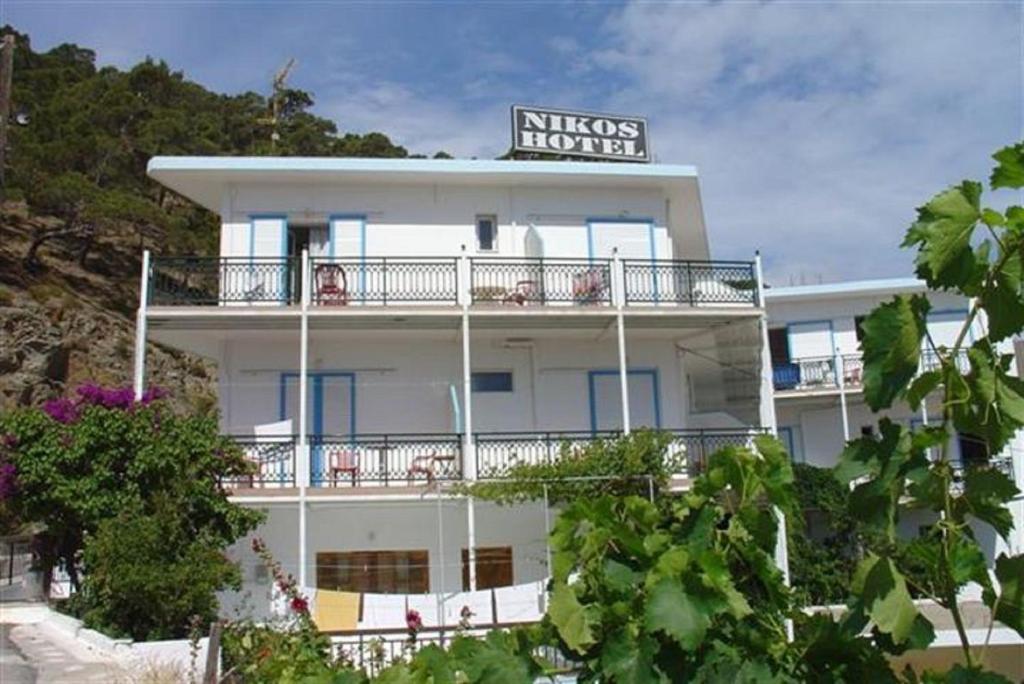 a white building with a sign on top of it at Nikos Hotel in Diafani