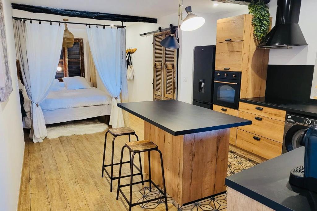 a kitchen with a bed and a kitchen with stools at Merveille de loft vue mer Citadelle de Bonifacio in Bonifacio