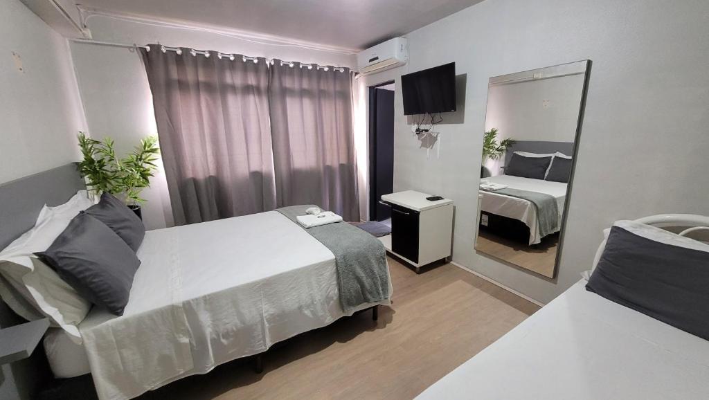 a hotel room with a bed and a mirror at Hotel e Restaurante do Baixinho in Planalto