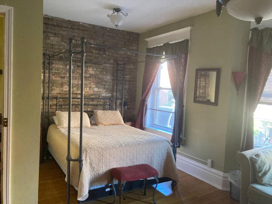 a bedroom with a bed and a brick wall at Large Private room with Queen bed - 2a in Chicago