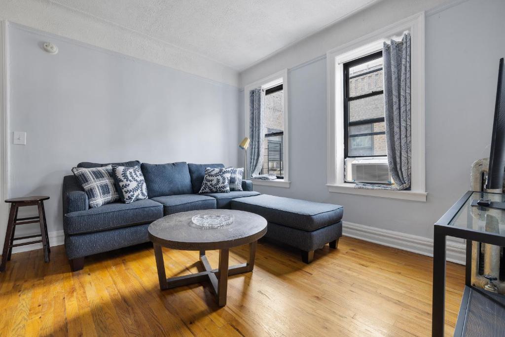 een woonkamer met een blauwe bank en een tafel bij Live Upper Manhattan on a Budget in New York