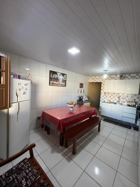 uma cozinha com uma mesa e um frigorífico em Lar da paz - Ilha da Crôa em Barra de Santo Antônio