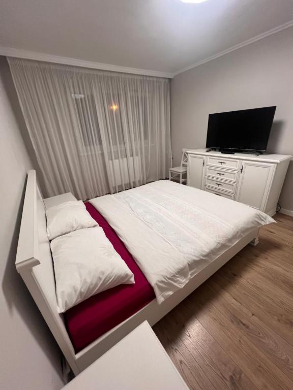 sypialnia z dużym łóżkiem i telewizorem w obiekcie Nymfa Residence w mieście Oradea