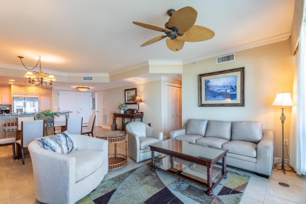 uma sala de estar com um sofá e uma ventoinha de tecto em 1 Portofino 1005 at Pensacola Beach em Pensacola Beach