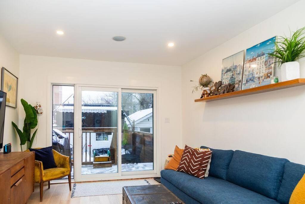 a living room with a blue couch and a window at Bright 3 bedroom house Downtown in Toronto