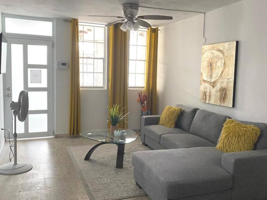 a living room with a couch and a table at AC Rooms, Smart TV, Centric & 20 mins from Airport in Loiza