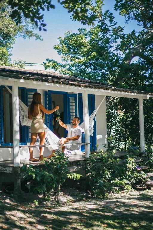 a man and a woman on the porch of a house at Pousada Lagoa in Caraíva