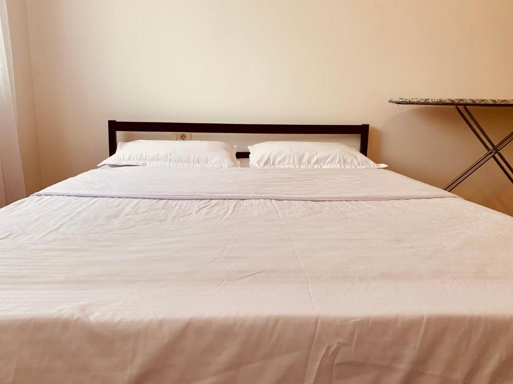ein großes weißes Bett mit zwei Kissen darauf in der Unterkunft Spacious apartment next to Royall Mall on B Street in Pristina