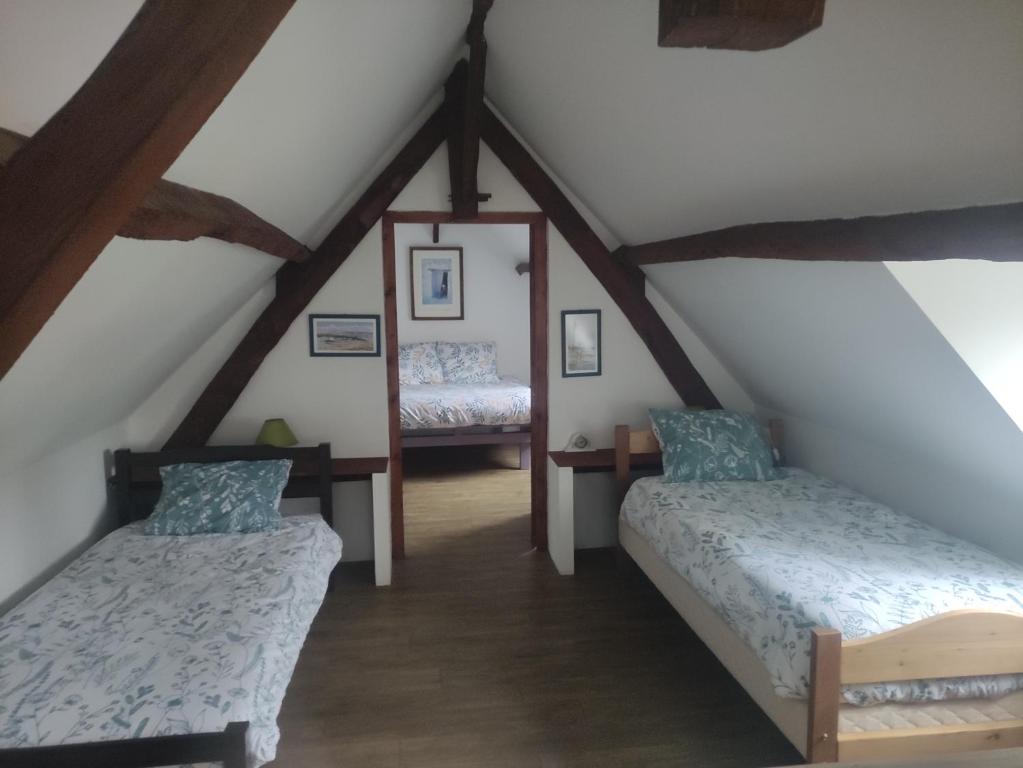 a attic room with two beds in a attic at LA PETITE GRANGE 