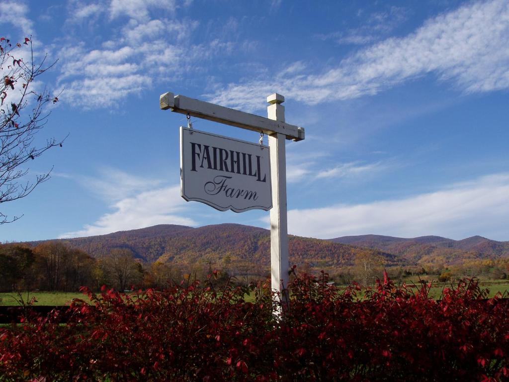 a sign for a farm with mountains in the background at Fairhill Farm Country Vacation Rentals in Stanardsville