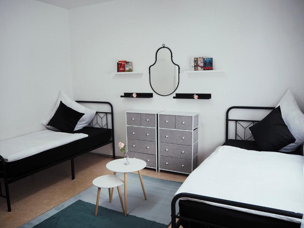 ノイマルクト・イン・デア・オーバープファルツにあるMonteurzimmer Stadtzentrumのベッドルーム1室(ベッド2台、テーブル、鏡付)