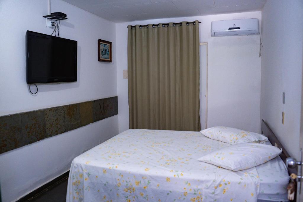 Il comprend une petite chambre avec un lit et une télévision à écran plat. dans l'établissement Pousada do Rio Corrente, à Santa Maria da Vitória
