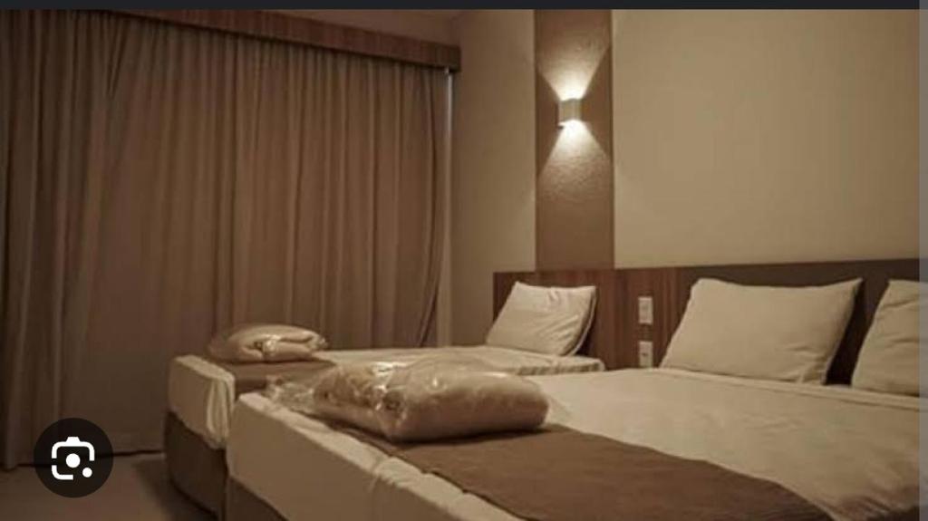 two beds in a hotel room at Prive Praias do Lago Ecoresort in Caldas Novas