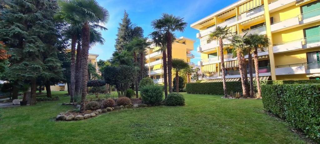 einen Park vor einem Gebäude mit Palmen in der Unterkunft Apartment 10 Palmen Locarno in Locarno