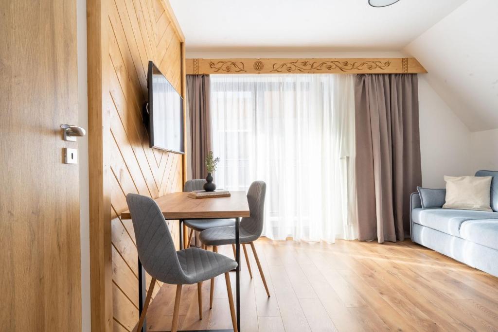 una habitación con una mesa y sillas y una cama en Ornak 7, en Zakopane