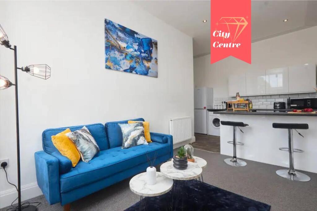sala de estar con sofá azul y cocina en Stylish 2 Bed Apt in Leeds Centre - FREE Parking! Contact us for Better Offers! en Leeds