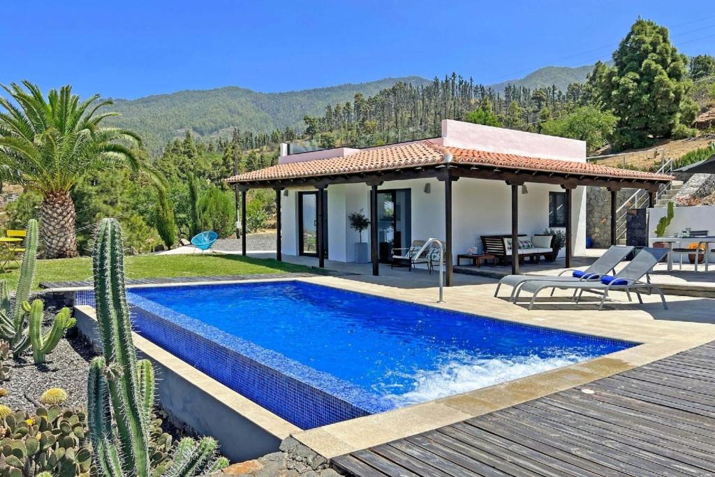 een villa met een zwembad en een huis bij Ferienhaus für 2 Personen ca 50 qm in Tijarafe, La Palma Westküste von La Palma in Tijarafe