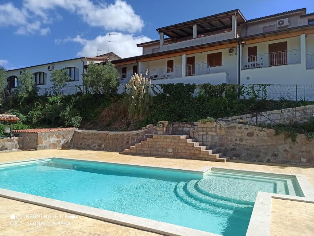 una piscina di fronte a una casa di Domus La Roccia a Pozzomaggiore