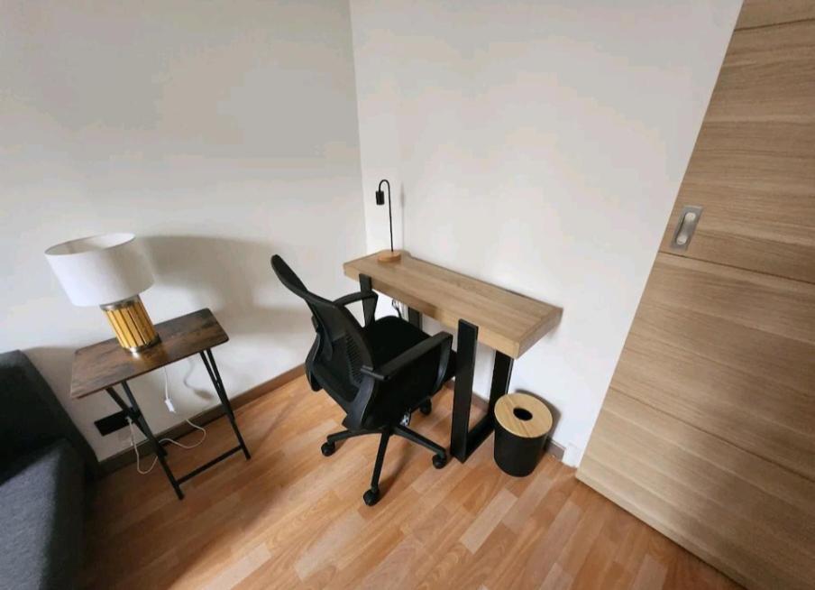 Zimmer mit einem Schreibtisch, einem Stuhl und einer Lampe in der Unterkunft Très beau 2 pièces à 400m de Paris in Gentilly