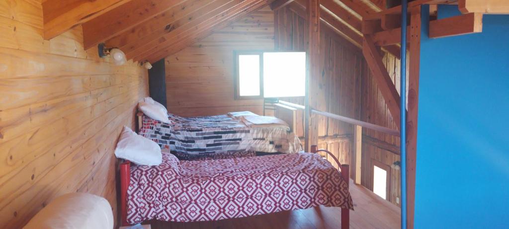 Los CipresesにあるLa Pancora del Futaの木造キャビン内のベッド2台が備わる部屋