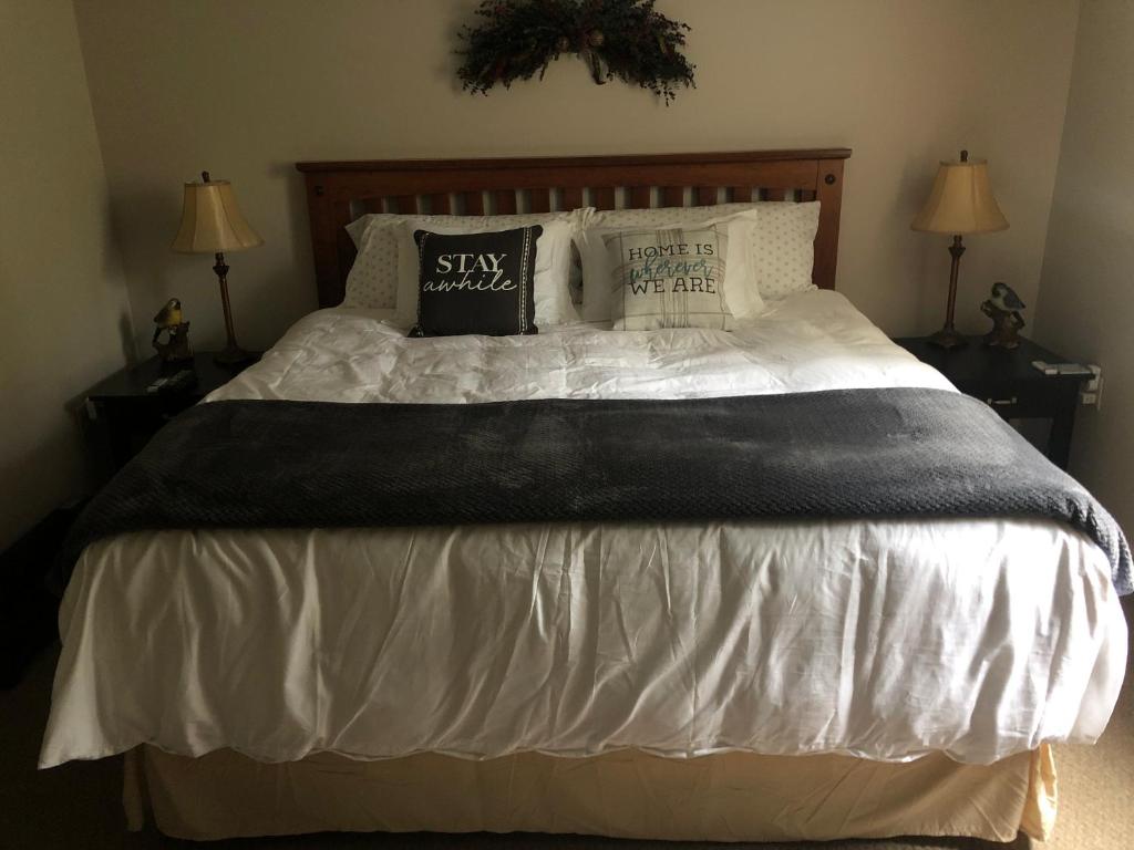 a bedroom with a large bed with white sheets and pillows at Plush garden level apartment near Stowe in Morristown