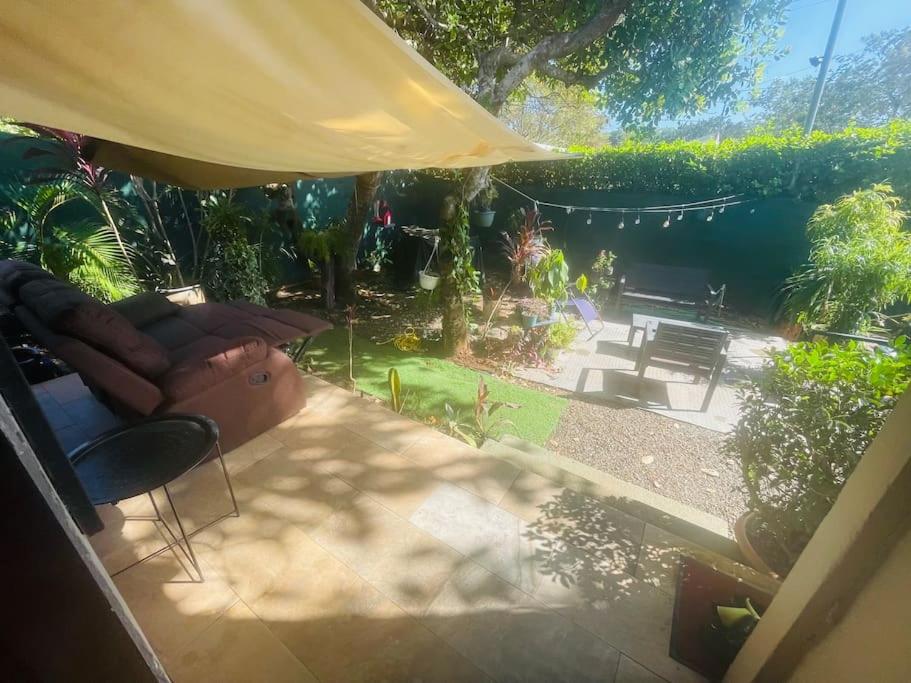 um quintal com um sofá, uma mesa e um guarda-chuva amarelo em Peace and love house em Huacas