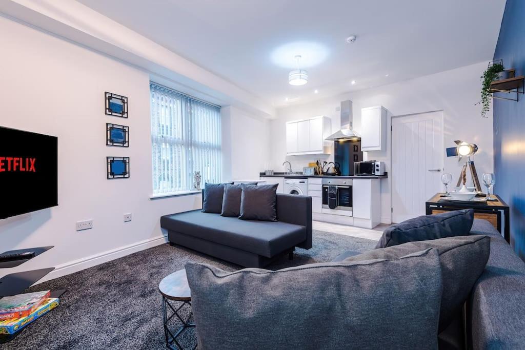 ein Wohnzimmer mit einem Sofa und einer Küche in der Unterkunft Spacious modern apartment in central location - free parking in Liverpool