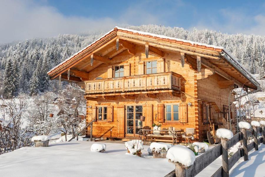 uma cabana de madeira na neve com árvores cobertas de neve em Ferienhaus Hirschhäusl em Reit im Winkl