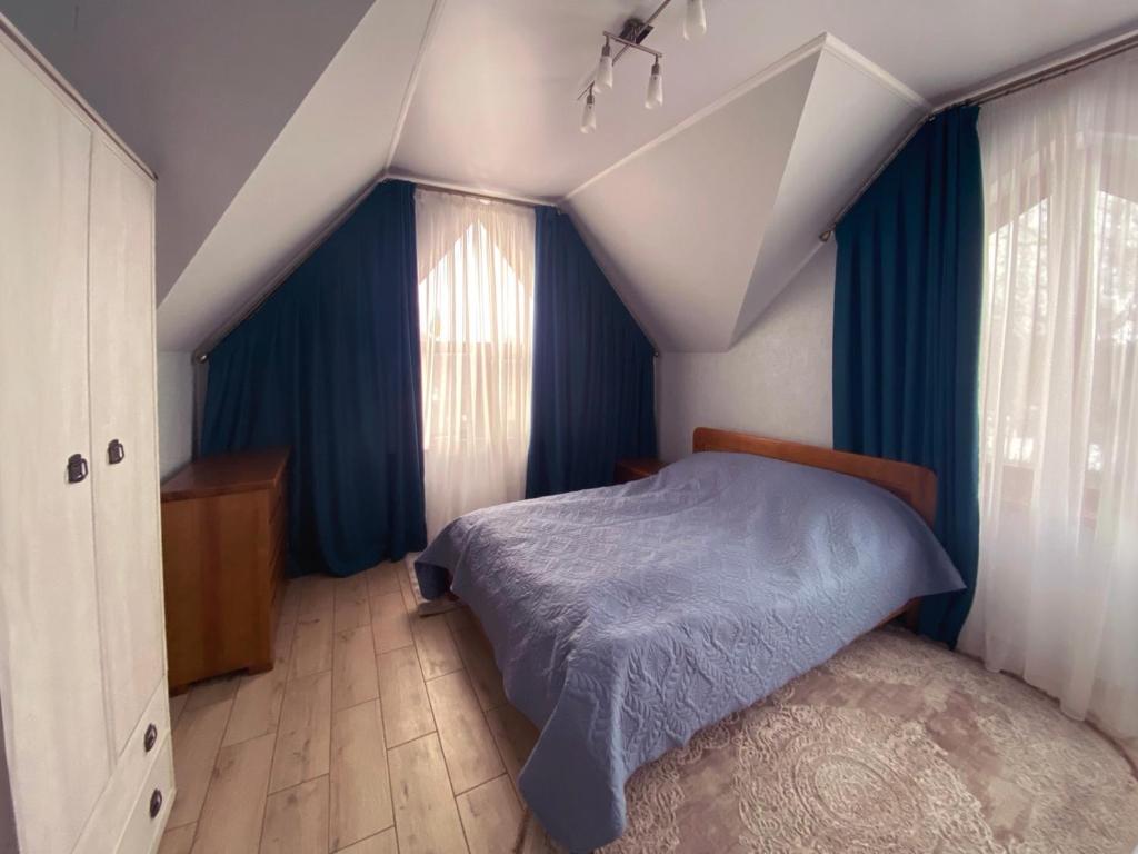 a bedroom with blue curtains and a bed in a room at Апартаменты in Vinnytsya