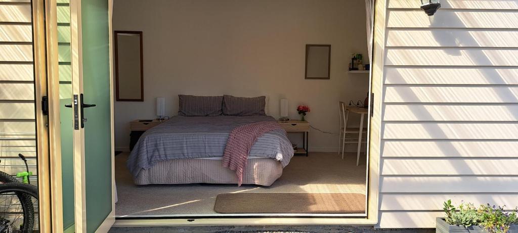a bedroom with a bed and a door leading to a doorway at 15 On Wards in Greytown