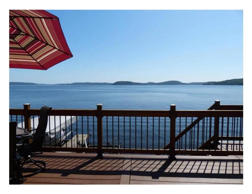 d'un balcon avec un parasol offrant une vue sur l'eau. dans l'établissement Waters Edge Cottage, à Merrimac