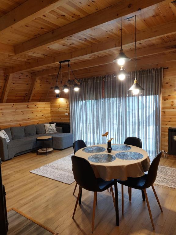 een eetkamer met een tafel en stoelen in een kamer bij Snowflake in Žabljak