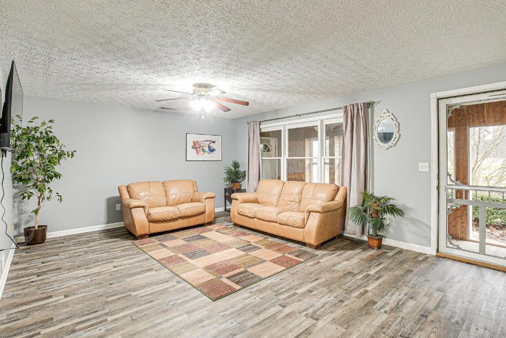 a living room with two chairs and a ceiling fan at Spacious Delaware Home with Private Hot Tub! in Delaware