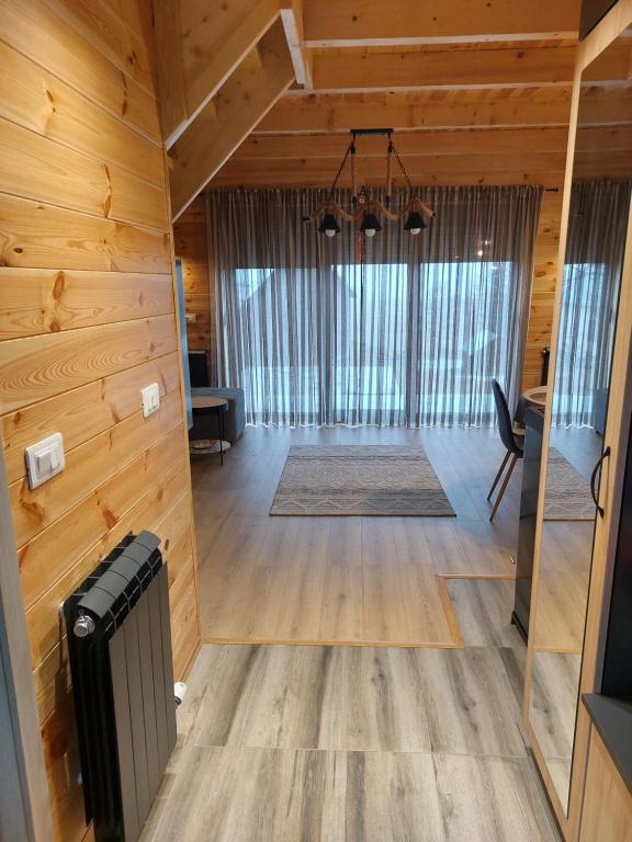 a large living room with wooden walls and a large window at Snowflake in Žabljak