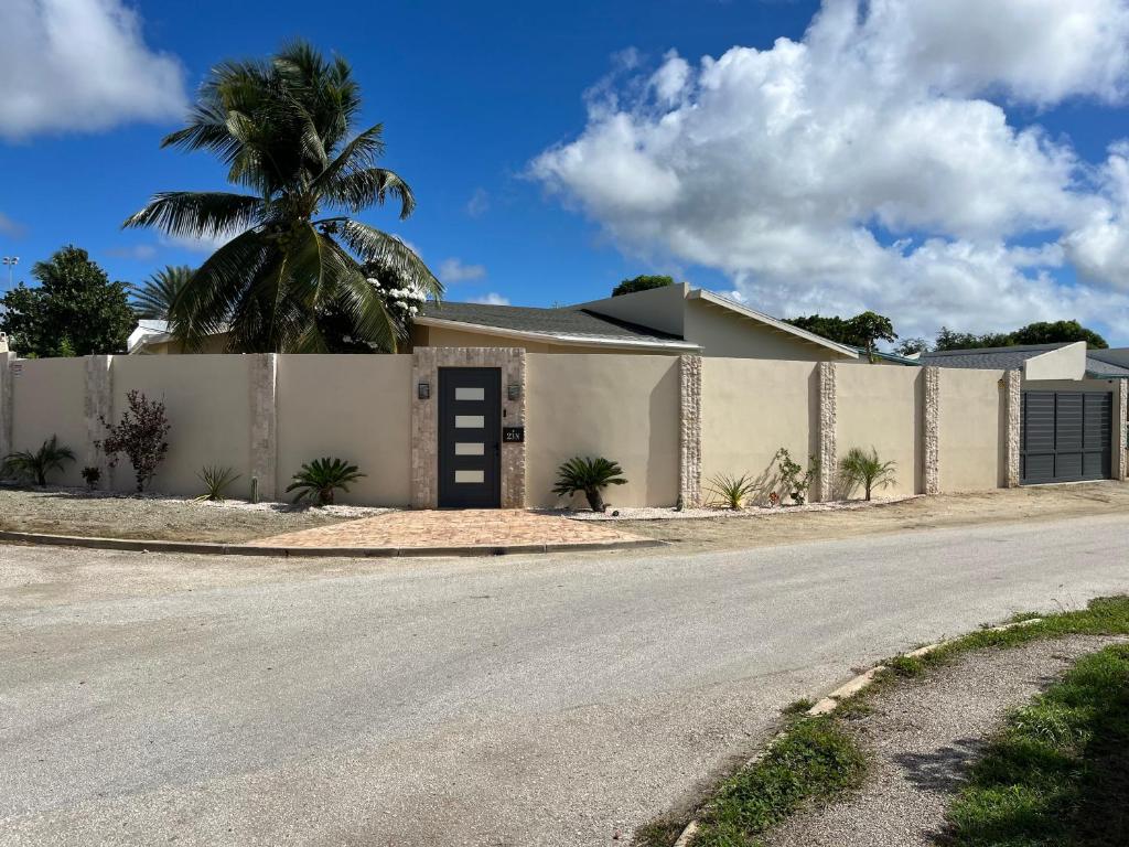 una casa con una recinzione e una palma di La Villas at Pos Chiquito Caribbean Paradise in Aruba a Savaneta