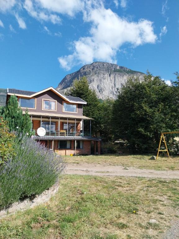 a house with a mountain in the background at Casa Cerro Divisadero in Coihaique