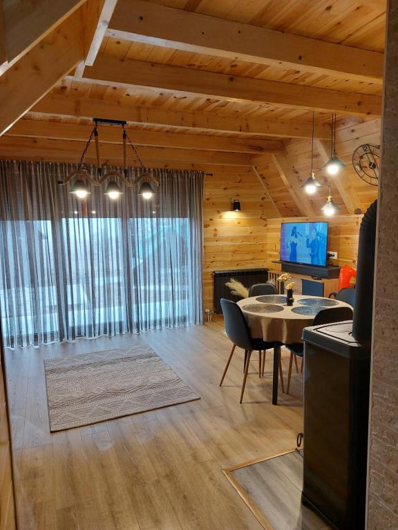 a living room with a table and chairs and a tv at Snowflake in Žabljak