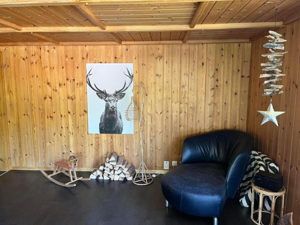 a room with a chair and a picture of a deer at Gemütliche 45 Zimmerwohnung in den Bündner Bergen bei Sedrun in Rueras
