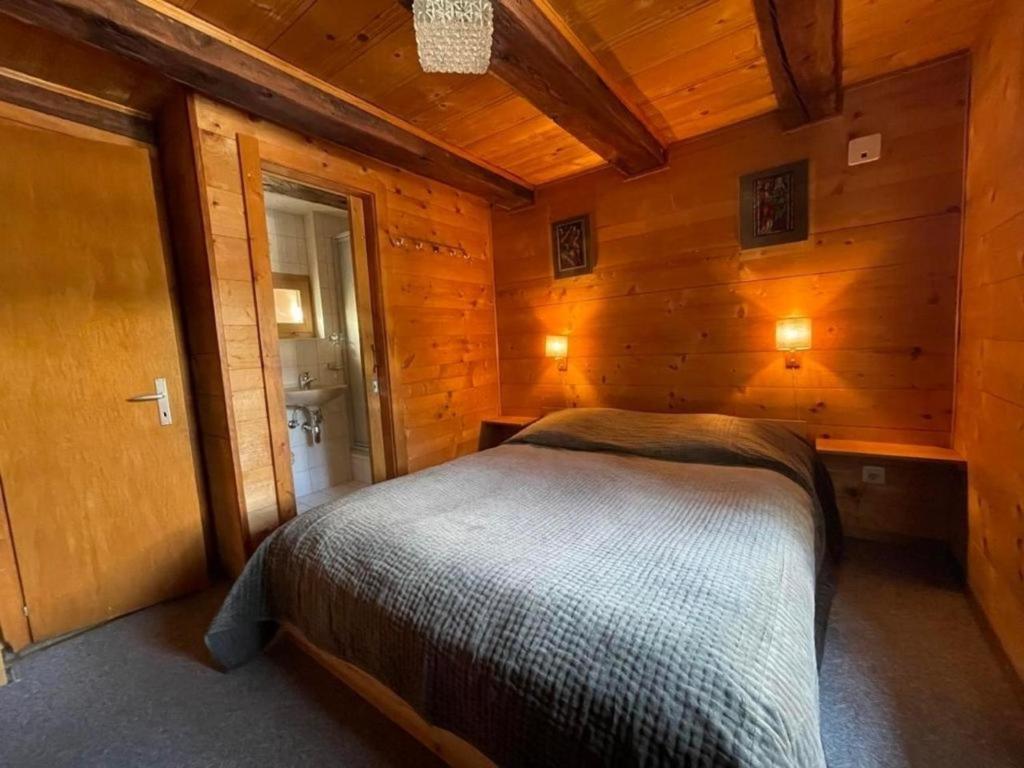 a bedroom with a bed in a wooden cabin at Chalet familial in Grimentz