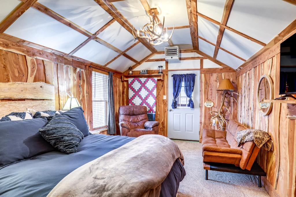 een slaapkamer met een bed en een stoel bij Glenvil Cabin with Gas Grill Steps to Dock and Pond! 