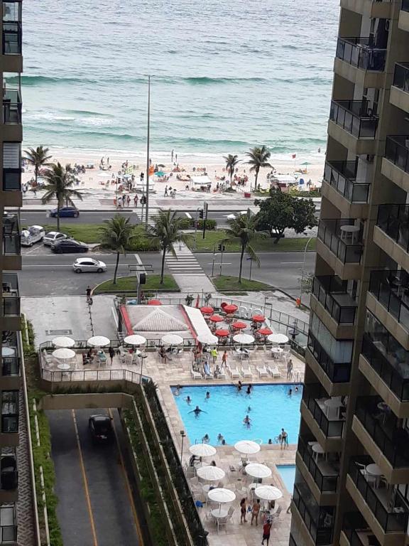 Hotel Apart na Praia da Barra da Tijuca ,Posto 6 Aptº inteiro para até 4 pessoas, a view of a pool and the beach from a building at Apart na Praia da Barra da Tijuca ,Posto 6 Aptº inteiro para até 4 pessoas in Rio de Janeiro