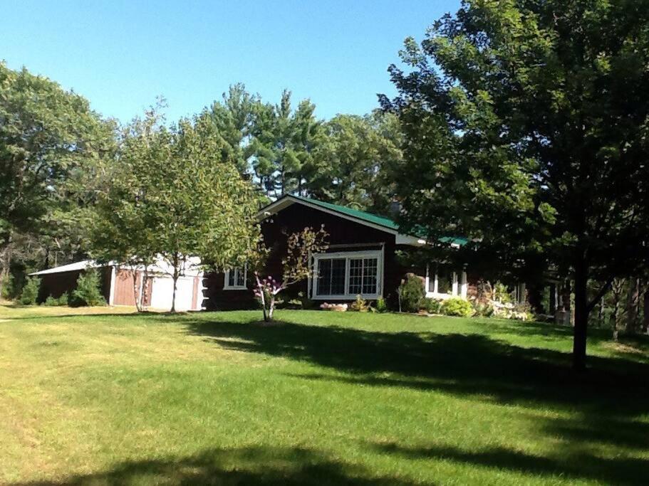 a house with a yard with trees and a house at Restful Retreat in Grantsburg