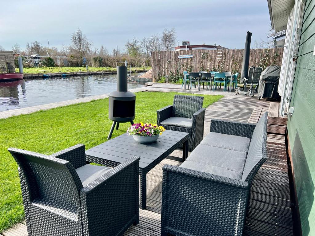 une terrasse avec une table, des chaises et une cuisinière dans l'établissement NEW - The Surf Shack - on a lake near Amsterdam!, à Vinkeveen