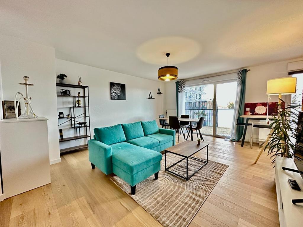 a living room with a blue couch and a table at La Frontalière in Ambilly